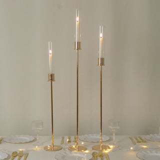 <meta charset="utf-8"><span><span><strong>Modern Glow: Gold Taper Candle Holder Trio with Glass Shades</strong></span></span>