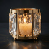 Gold candle holder with crystal panels and lit candle, luxury decor