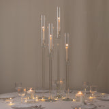 Elegant glass candle holders with lit candles for table decor.