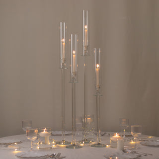 Elegant glass candle holders with lit candles for table decor.