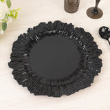 Black decorative plate with a ruffled edge on a light wooden surface.
