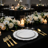 Elegant table setting with gold utensils, white plates, and floral decor.