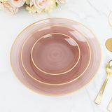 Elegant pink dinner plate with gold rim accents on a marble surface.