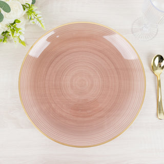 Elegant pink plate with a gold rim on a wooden table.