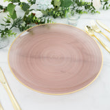 Rose gold decorative plate with spiral design on a marble table setting.