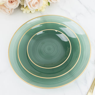 Set of three green decorative plates with gold rims on a marble surface.