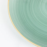 Green ceramic plate with textured design and gold rim