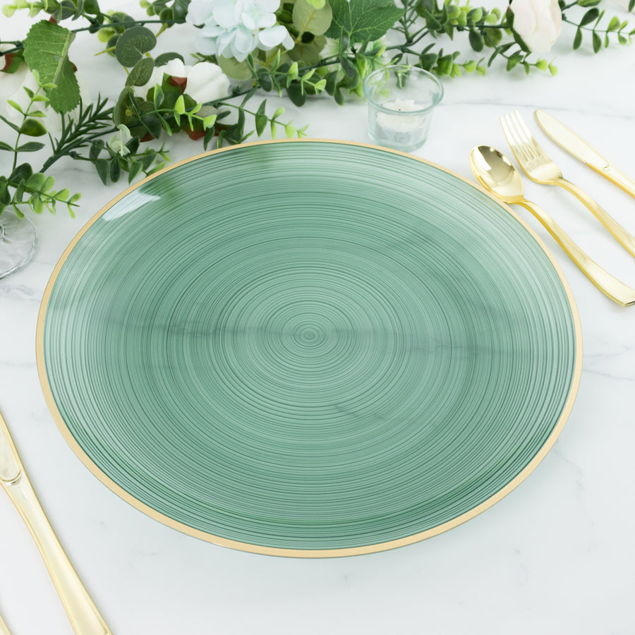 Green decorative plate with gold rim, surrounded by greenery and utensils.