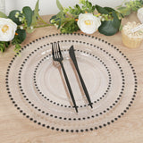 Elegant clear plate set with black utensils and decorative floral accents.