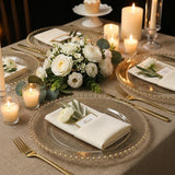 Elegant dining table setting with floral centerpiece and candles.