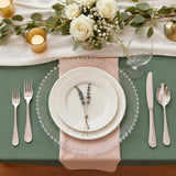 Elegant table setting with plates, cutlery, and floral centerpiece.