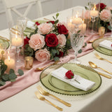 Elegant table setting with roses, candles, and glassware for a romantic occasion.