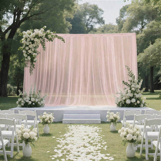 Elegant outdoor wedding ceremony setup with blush draping and white floral decor