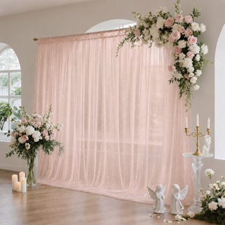 Blush pink wedding backdrop with floral arrangements and candles