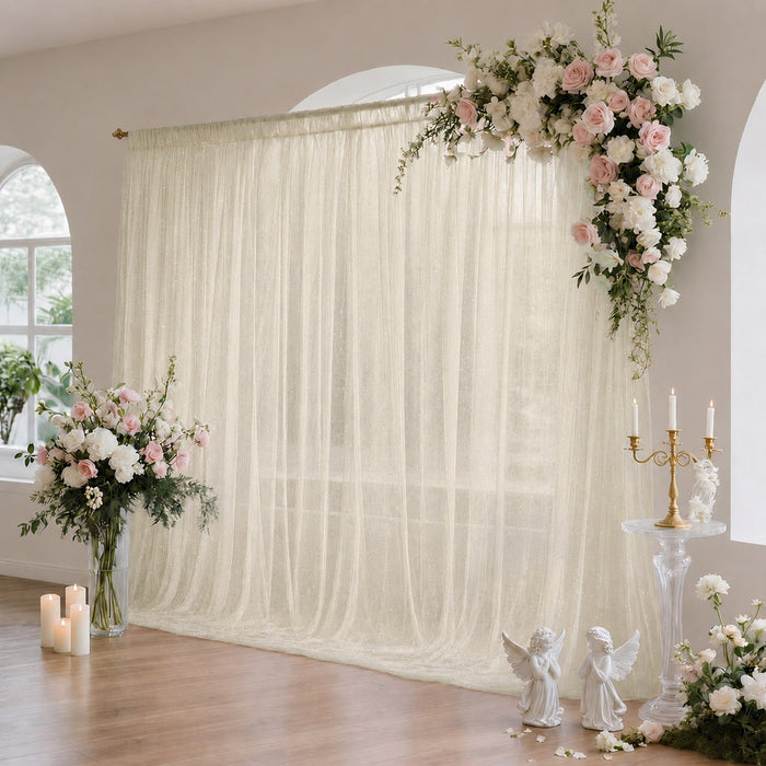 Elegant wedding floral backdrop with white drapery, pink roses, and candles