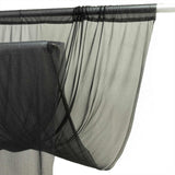 Sheer black curtain panel on a rod, close-up with gathered ties