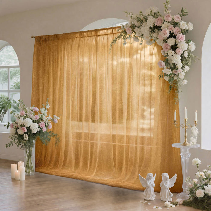 Elegant wedding floral arch with golden draped backdrop and candles