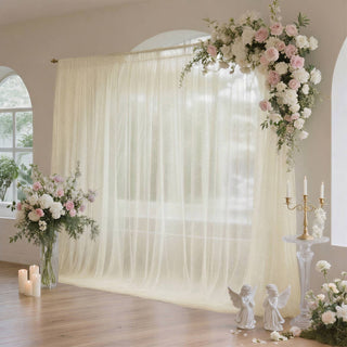 Elegant wedding backdrop with blush roses, white drapery, and candles