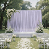 Elegant outdoor wedding ceremony setup with white floral arch and aisle petals