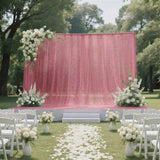 Pink outdoor wedding ceremony backdrop with white floral arrangements and chairs