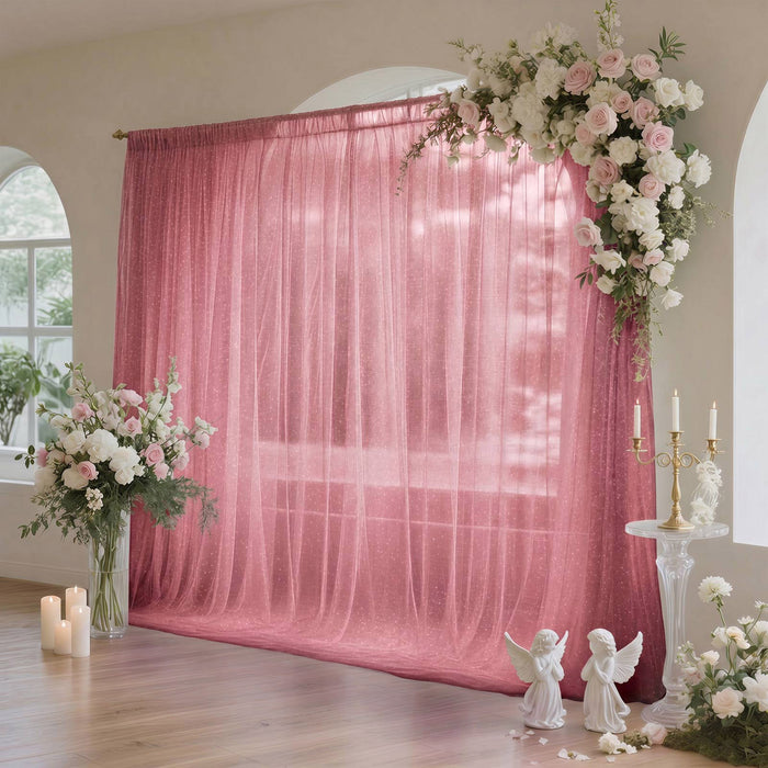 Pink wedding backdrop with floral arch, candles, and angel decor in elegant room