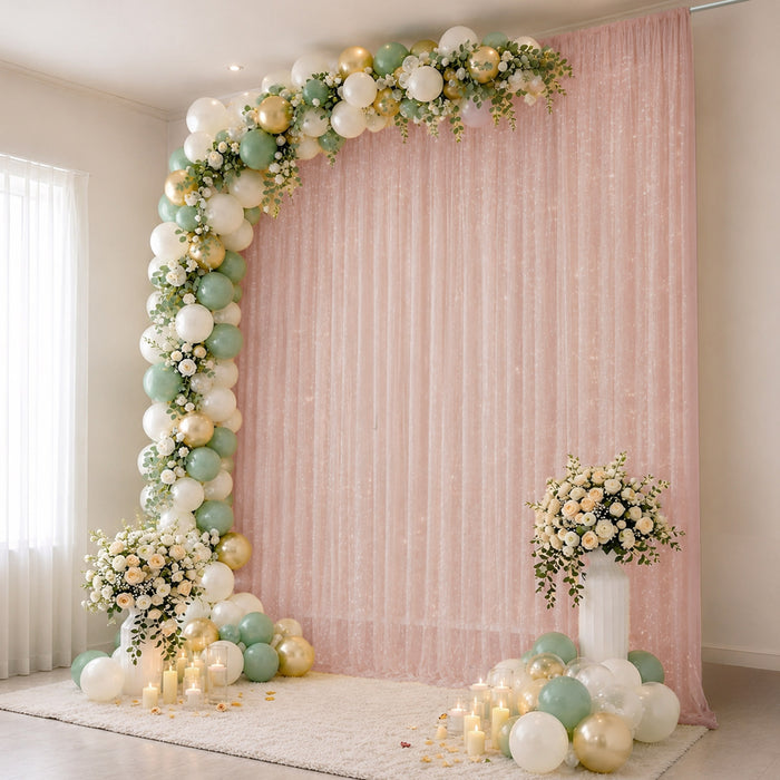 Pastel balloon arch with floral decor and pink backdrop for elegant party setup