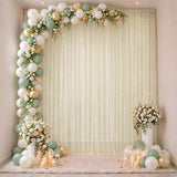 Elegant pastel balloon and floral event backdrop with candles and drapery