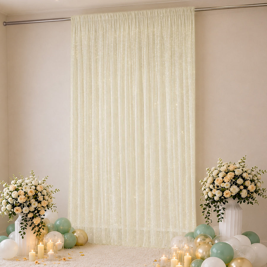Elegant cream wedding backdrop with floral arrangements, balloons, and candles