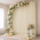 Elegant pastel balloon and floral party backdrop with candles and drapery