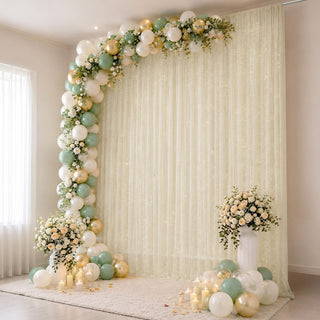 Elegant pastel balloon and floral party backdrop with candles and drapery