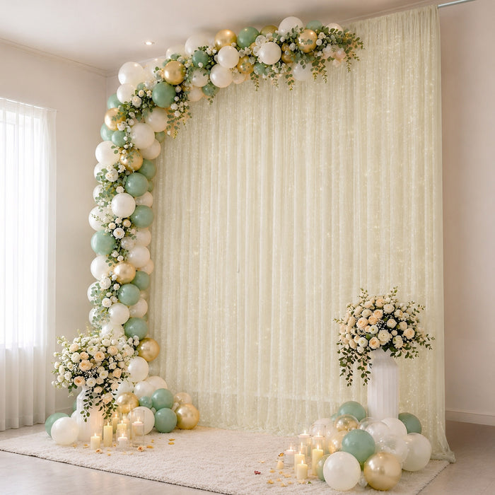 Elegant pastel balloon and floral party backdrop with candles and drapery