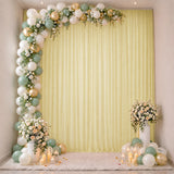 Elegant pastel balloon and floral party backdrop with candles and draped curtain