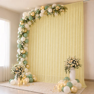 Elegant pastel balloon and floral event backdrop with candles and draped curtain