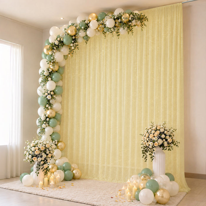 Elegant pastel balloon and floral event backdrop with candles and draped curtain