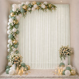 Pastel balloon arch and floral wedding backdrop with candles and greenery