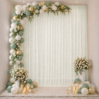 Pastel balloon arch and floral wedding backdrop with candles and greenery