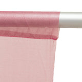 Pink sheer curtain fabric on a white curtain rod close-up