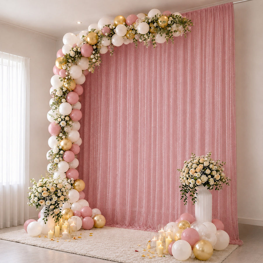 Pink and gold balloon arch with floral backdrop for elegant party decor