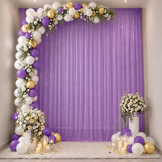 Purple, white and gold balloon arch with floral backdrop and candles for party decor