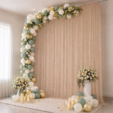 Elegant pastel balloon and floral party backdrop with candles and curtains
