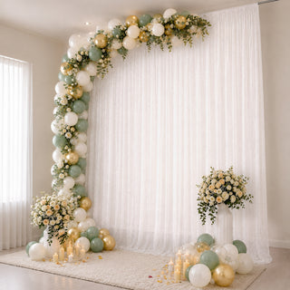 Elegant balloon and floral wedding backdrop with candles and draped white curtains