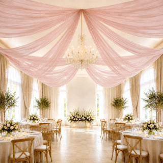 Elegant blush wedding reception hall with chandelier and floral table decor