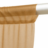 Sheer gold curtain panel hanging on a white curtain rod