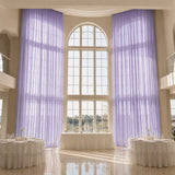 Elegant lavender drapes in a grand wedding reception hall with tall arched windows