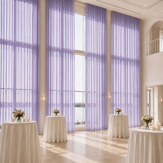 Elegant wedding reception hall with lavender drapes and cocktail tables by large windows