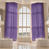 Elegant banquet hall with tall purple drapes and arched window decor