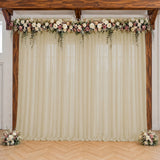 Elegant wedding arch with floral garland and ivory drapes indoors