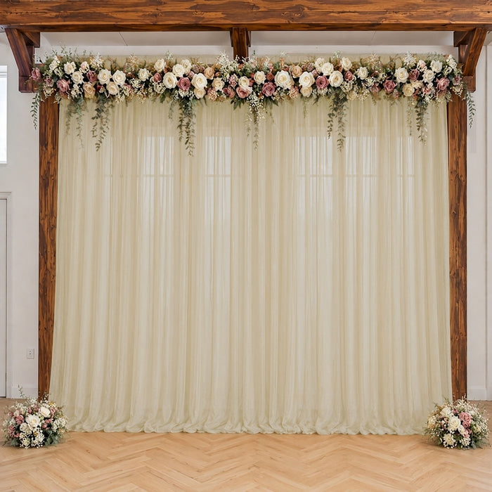Elegant wedding arch with floral garland and ivory drapes indoors