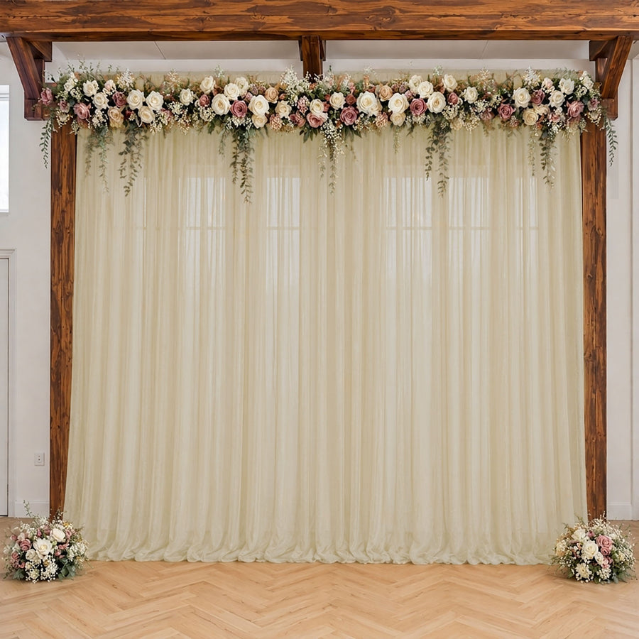 Elegant wedding arch with floral garland and ivory drapes indoors