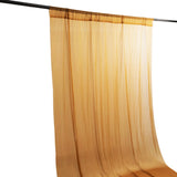 Gold sheer curtain panel hanging on a rod, elegant window treatment